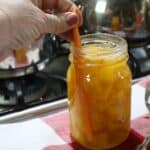 Removing bubbles from a jar of pumpkin cubes.