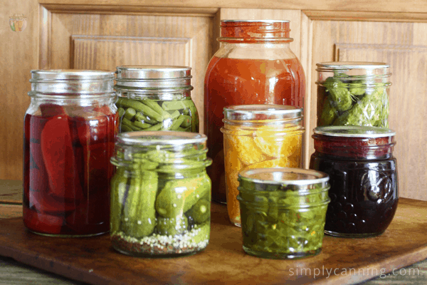 Jars of home canned pickles and more arranged together.