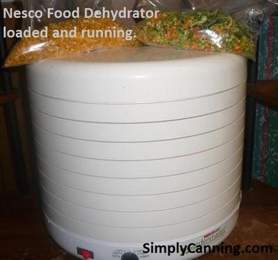 Bags of dehydrated food sitting on top of the round white Nesco food dehydrator.