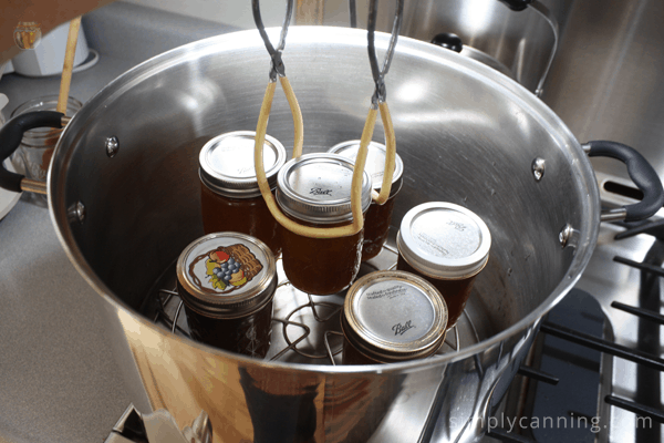 Lifting jars of peach jam into the steam canner.