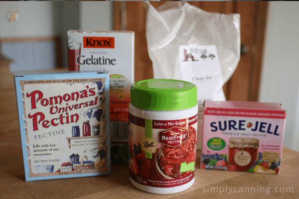 Packages of pectin and gelatin and Clear Jel sitting on the countertop.