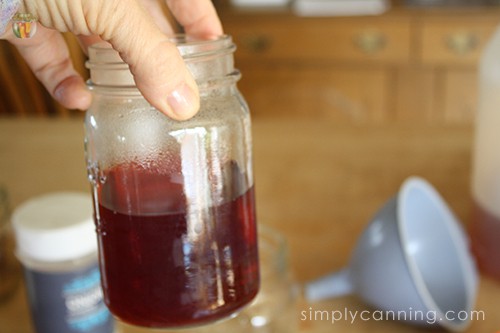 Sharon holding a jar of red pickled beet juice.