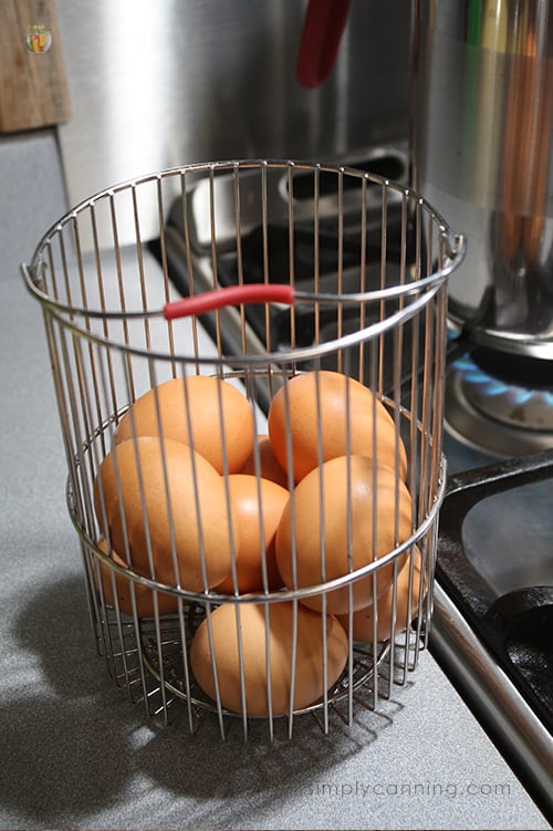 Large brown eggs sitting in the fourth burner pot basket next to the stove.