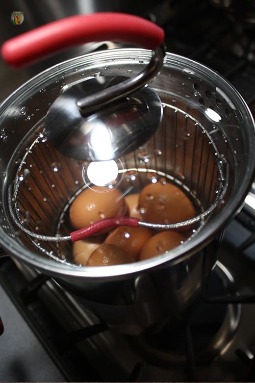 Looking through the clear glass lid into the fourth burner pot where the eggs are cooking.