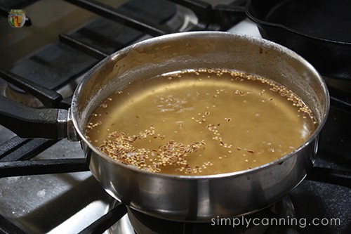 A pot of vinegar with spices floating in it.