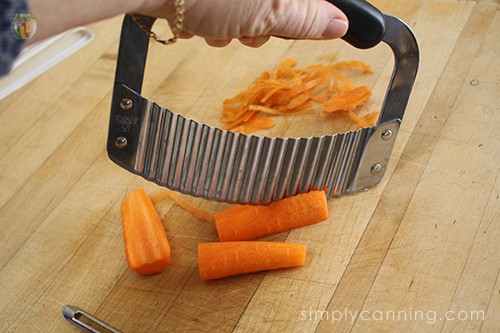 Using the crinkle cutter to slice carrots into smaller pieces.