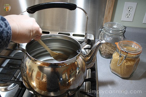 Stirring together the brine in a stainless steel tea kettle.