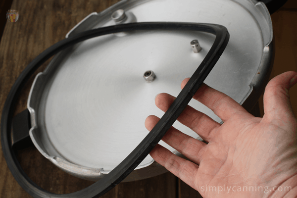 Sharon holding the separated sealing ring over the upside down canner lid.