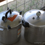 Bulky All American canner sitting next to the sleeker Presto pressure canner.