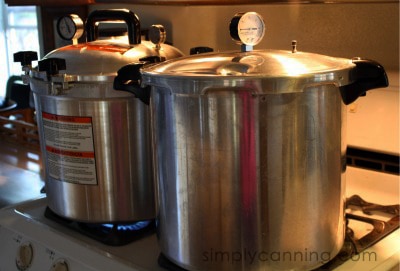 All American and Presto pressure canners sitting side by side on the stovetop.