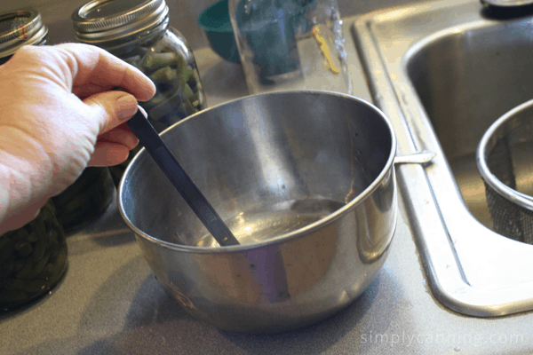 Canning lids in a bowl of hot water.