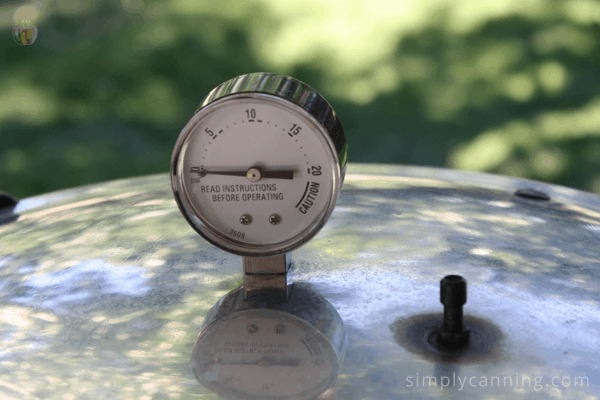 Dial gauge and vent on the pressure canner lid.