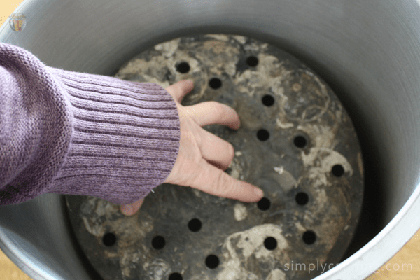 Placing the rack on the bottom of the pressure canner.