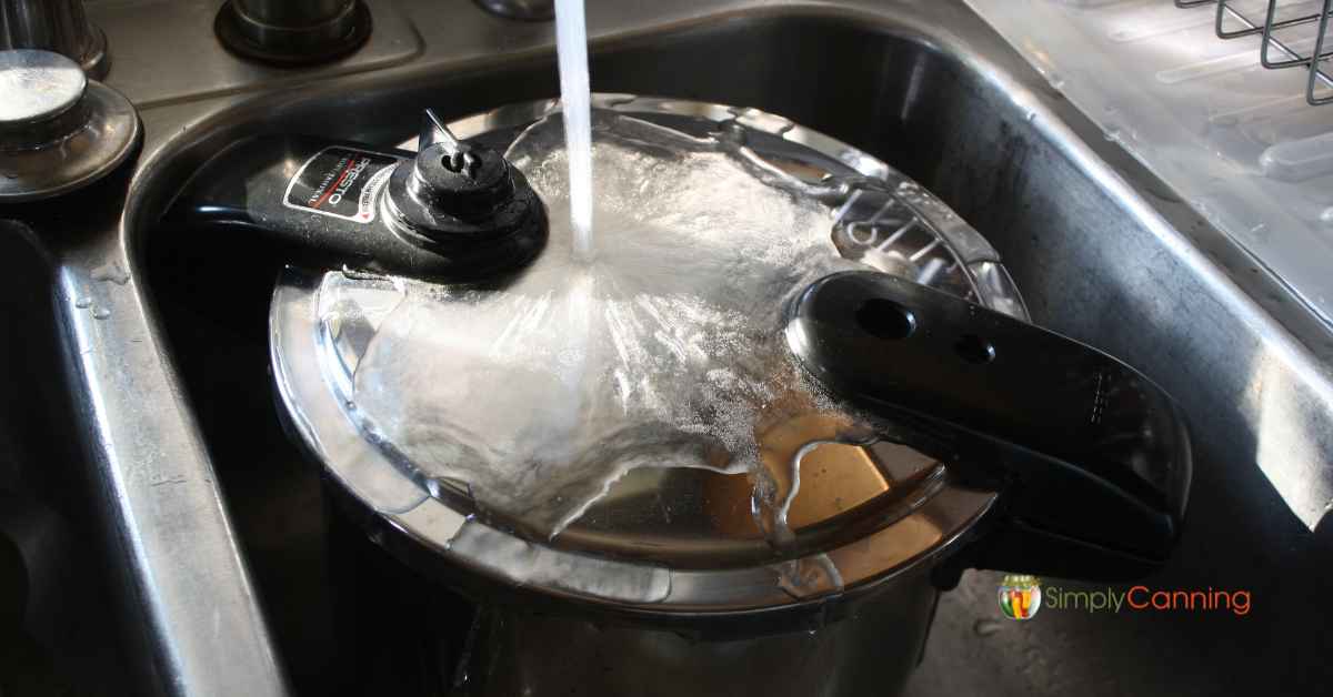 Pouring cold water over the pressure cooker to cool it down.