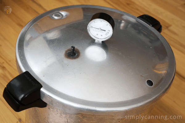 Looking down at the clean Presto pressure canner lid with its dial and vent.