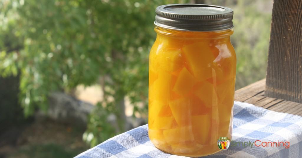 A pint jar filled with canned pumpkin cubes.