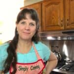 Sharon's profile image standing in the kitchen with her Simply Canning apron on.