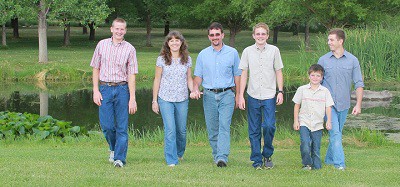 Sharon walking with her husband and sons outdoors.