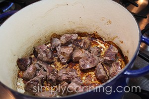 Cubes of venison browning in a Dutch oven.