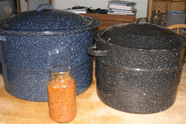 Blue and black graniteware canners sitting on the countertop.